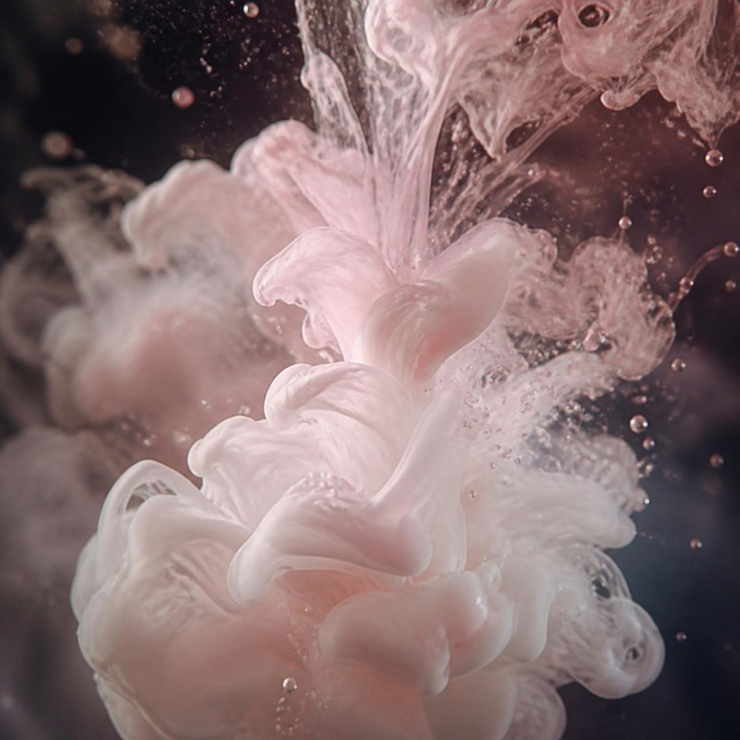 White cream dispersing through clear water